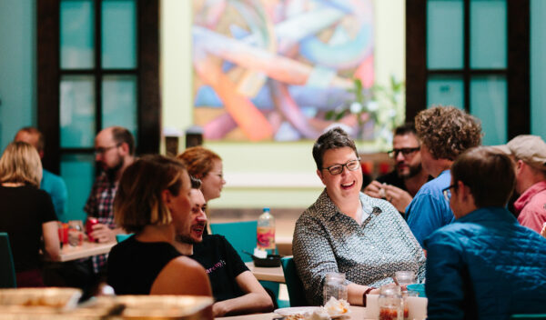 Pixo CEO Melinda Miller smiling while sitting at a table with colleagues