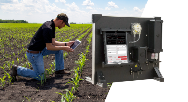 Farmer using an iPad in a field with the SoilScan device