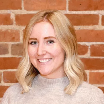 Jackie, a woman with long light hair in a navy blue shirt, smiling