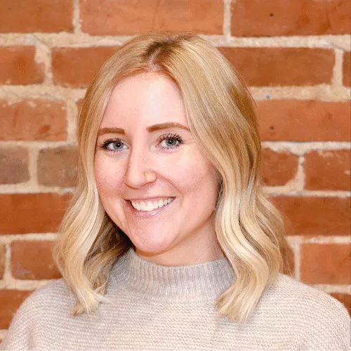 Jackie, a woman with long light hair in a navy blue shirt, smiling