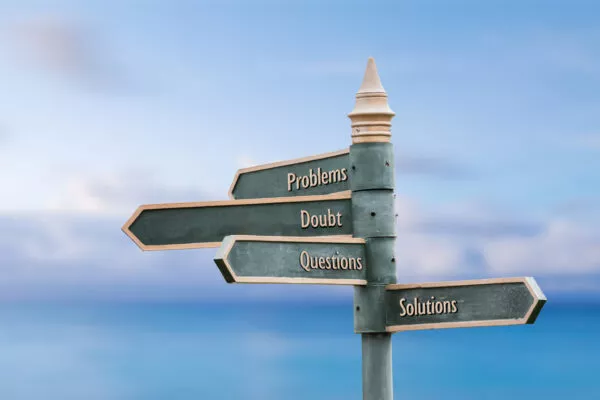 Problems, doubt, questions, solutions. Four word quote written on fancy steel signpost outdoors by the sea. Soft Blue ocean bokeh background.