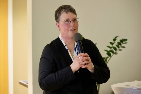 Melinda holding microphone and speaking