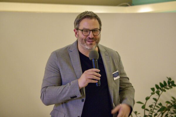 Jason holding microphone and speaking