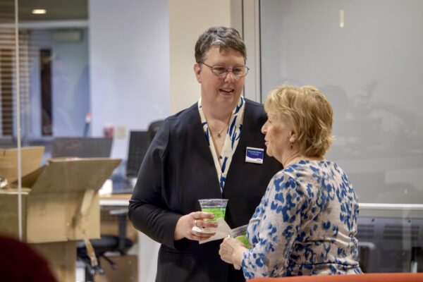 Melinda standing talking with a guest
