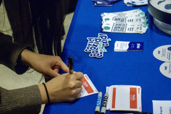 The welcome table showing a person's hands as they fill out a nametage