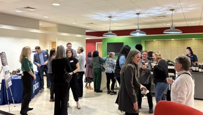 Guests standing and enjoying refreshments in the building's atrium