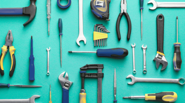 a variety of hand tools laid out neatly across a bright aqua background