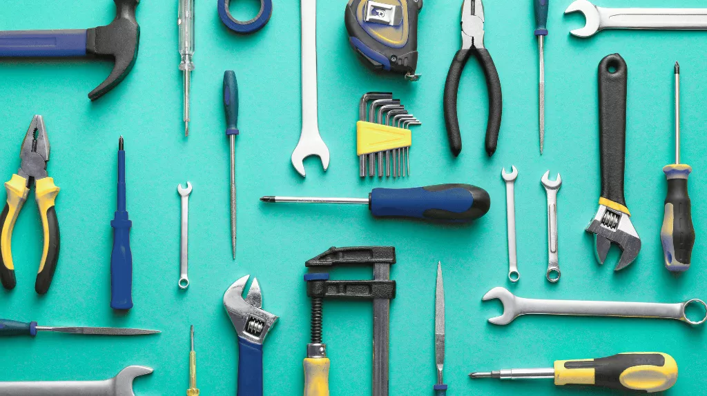 a variety of hand tools laid out neatly across a bright aqua background