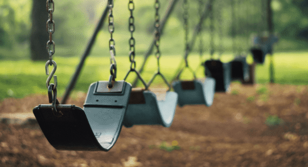 closeup of swings in a verdant park
